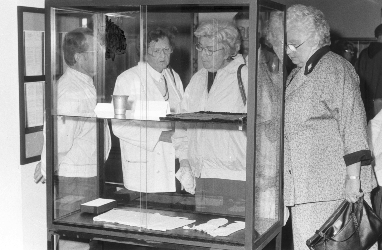 Frauen blicken auf Objekte in einer Vitrine. Eröffnung der ersten Speziallager-Ausstellung in Buchenwald, 14. September 1990, Foto: Gedenkstätte Buchenwald